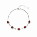 Silver-colored January birthstone bracelet on a white background, with five oval garnets, clear halo borders, a Cuban chain, and an extension with a heart-shaped tag.