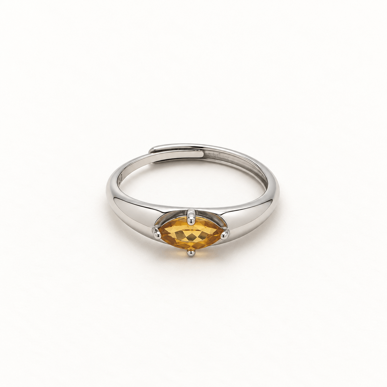 Front view of a marquise citrine ring on a cream-white background, showing the horizontal golden-yellow gemstone, four-prong setting, and overlapping silver-colored band.